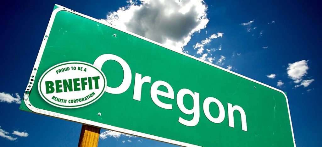 A green highway sign for Oregon with a sticker on it that says "Proud to be a benefit corporation."